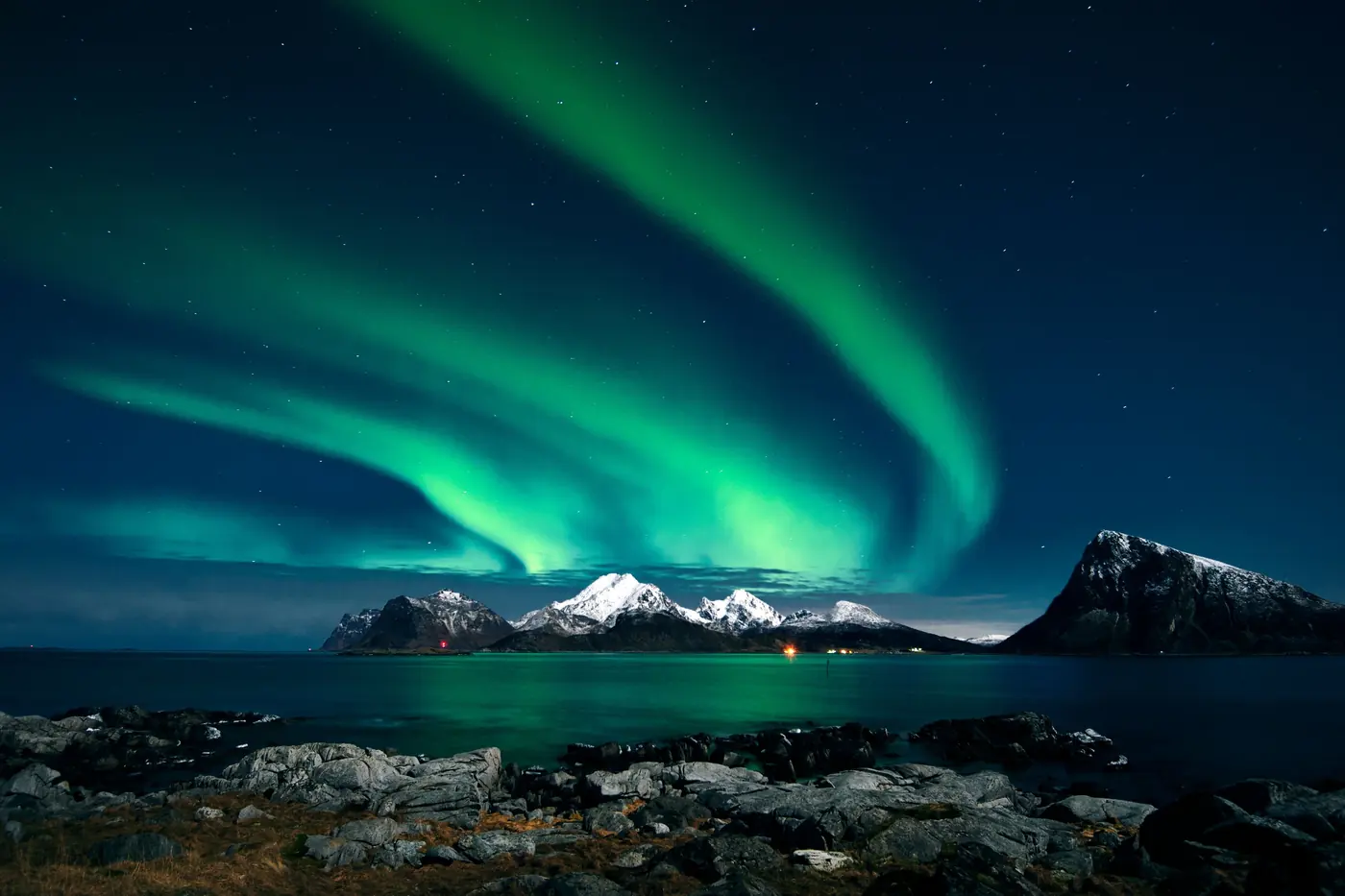 Aurora over the harbour and drying racks at Henningsvaer in Lofoten